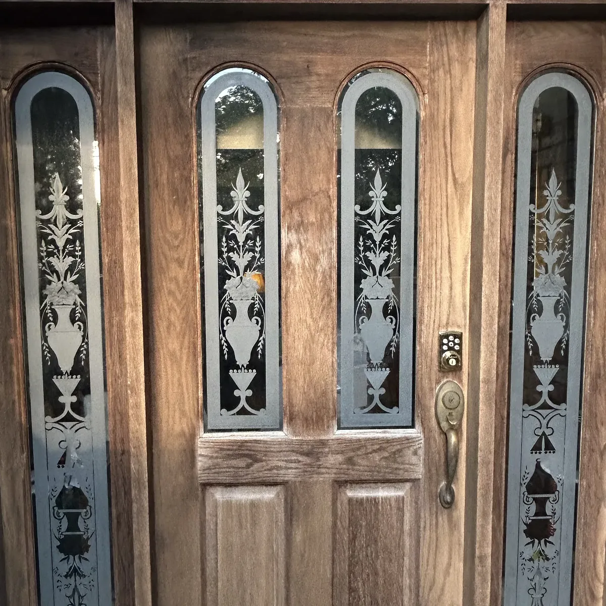 Weathered oak front door and etched-glass sidelights before refinishing in Tulsa